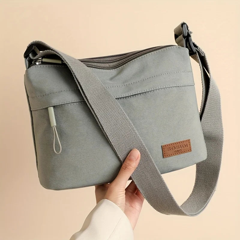 This large-capacity crossbody bag for women features a multi-zipper design and adjustable shoulder straps, making it suitable fo