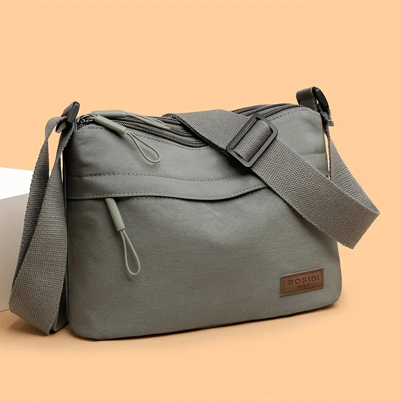 This large-capacity crossbody bag for women features a multi-zipper design and adjustable shoulder straps, making it suitable fo